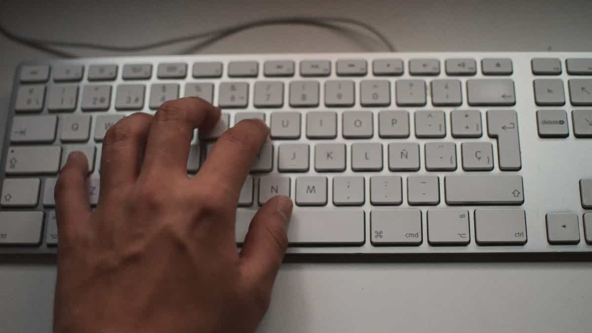 a hand typing on a keyboard
